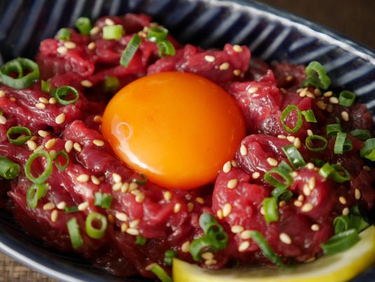赤身馬刺しを細切りにして韓国料理風に味つけしタレを絡め中央に卵黄を乗せた「馬 ユッケ」の画像