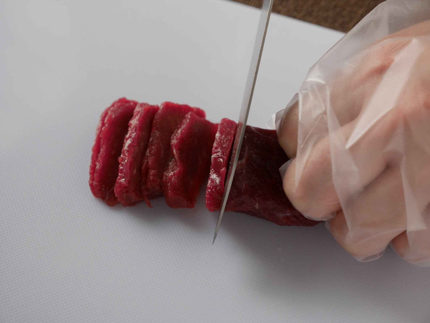 熊本馬刺し もっこすセット 半解凍になったブロック馬肉をスライスしているた調理例
